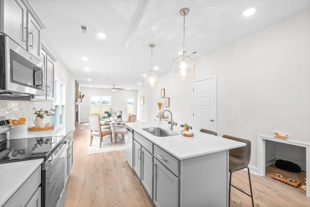 1002 Cherry Acres, Clarksville, TN 37042 - kitchen featuring appliances with stainless steel finishes, a sink, gray cabinetry, a breakfast bar area, and decorative backsplash
