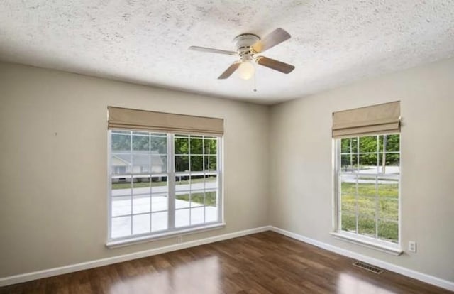 380 Station Dr, Waverly, TN 37185 - unfurnished room with dark wood-type flooring, healthy amount of natural light, baseboards, and a textured ceiling