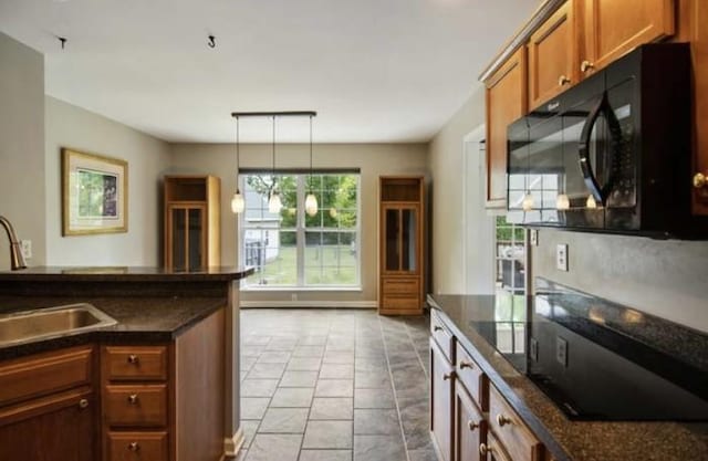 380 Station Dr, Waverly, TN 37185 - kitchen with black microwave, a sink, brown cabinets, and decorative light fixtures