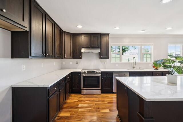 2408 Cantor Way, Spring Hill, TN 37174 - kitchen with appliances with stainless steel finishes, a sink, under cabinet range hood, healthy amount of natural light, and crown molding