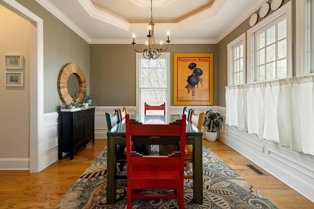 3448 Colebrook Dr, Thompsons Station, TN 37179 - dining room with a chandelier, a raised ceiling, light wood-type flooring, a wainscoted wall, and ornamental molding
