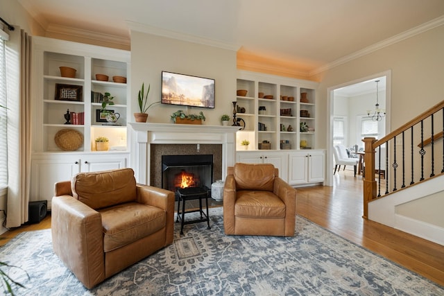 3448 Colebrook Dr, Thompsons Station, TN 37179 - living area with ornamental molding, a lit fireplace, wood finished floors, stairway, and a chandelier