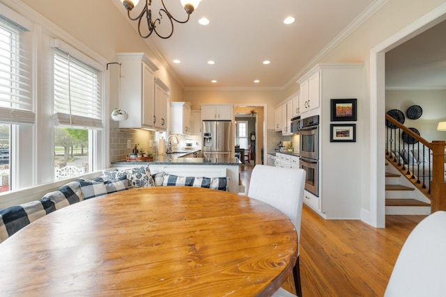3448 Colebrook Dr, Thompsons Station, TN 37179 - dining area with stairway, recessed lighting, light wood-style floors, a chandelier, and ornamental molding