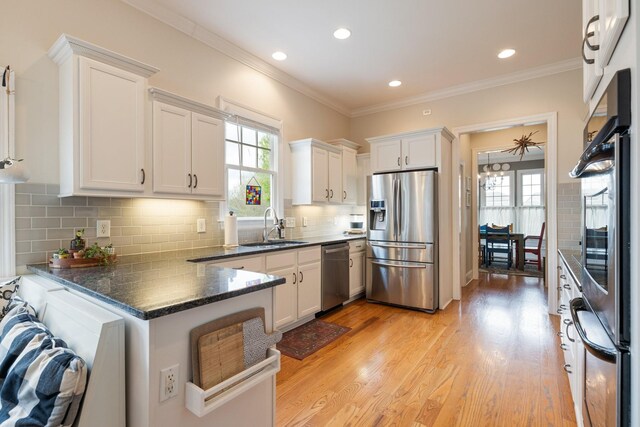 3448 Colebrook Dr, Thompsons Station, TN 37179 - kitchen featuring stainless steel appliances, a sink, a peninsula, white cabinetry, and tasteful backsplash