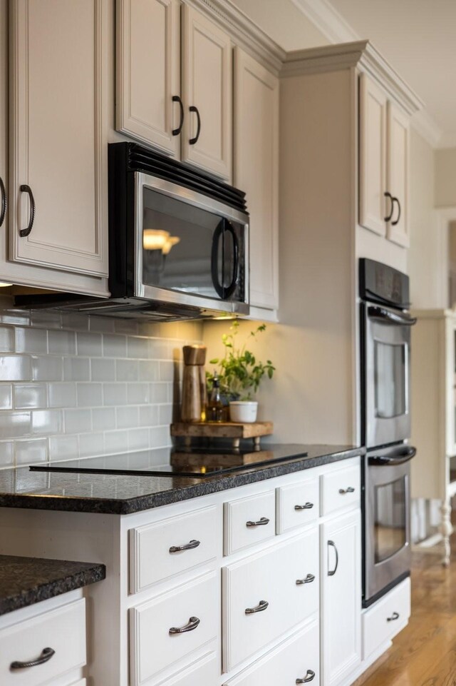 3448 Colebrook Dr, Thompsons Station, TN 37179 - kitchen with stainless steel appliances, decorative backsplash, dark stone countertops, and light wood finished floors