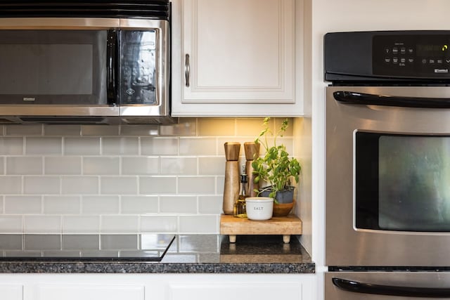 3448 Colebrook Dr, Thompsons Station, TN 37179 - kitchen with stainless steel appliances, decorative backsplash, white cabinetry, and dark countertops