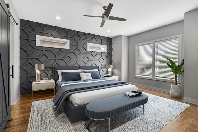 525 31st Ave N Unit A, Nashville, TN 37209 - bedroom with baseboards, a barn door, recessed lighting, an accent wall, and wood finished floors