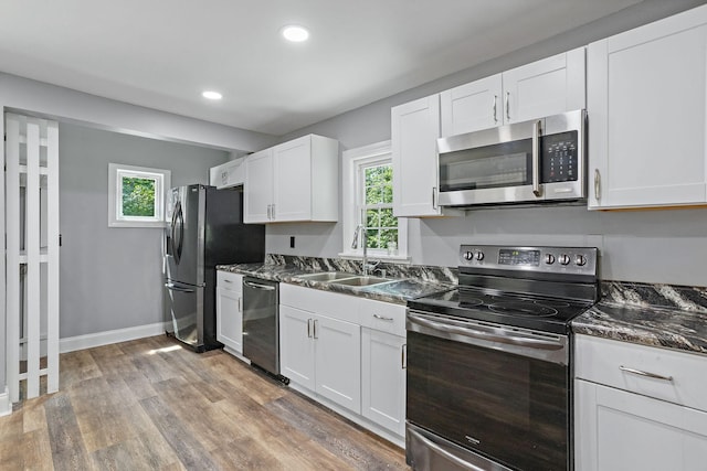 2614 Flamingo Dr, Nashville, TN 37207 - kitchen featuring appliances with stainless steel finishes, a sink, white cabinetry, light wood finished floors, and recessed lighting