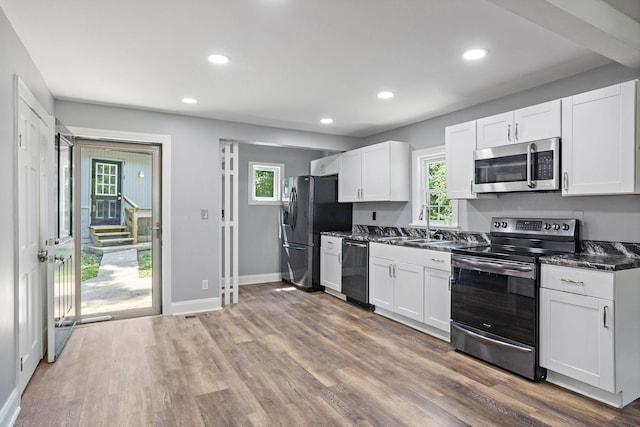 2614 Flamingo Dr, Nashville, TN 37207 - kitchen with appliances with stainless steel finishes, white cabinets, wood finished floors, recessed lighting, and baseboards