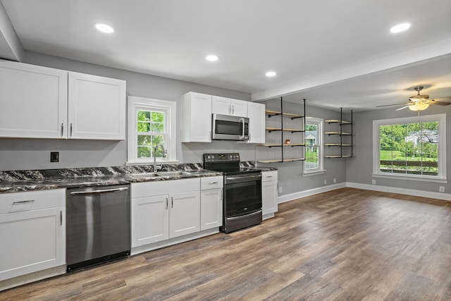 2614 Flamingo Dr, Nashville, TN 37207 - kitchen with stainless steel appliances, a sink, baseboards, white cabinets, and wood finished floors