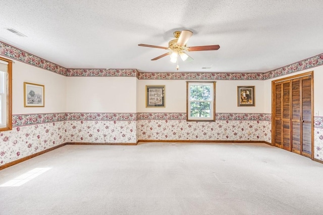 220 Winton Way Rd, Manchester, TN 37355 - spare room with wallpapered walls, carpet flooring, ceiling fan, and a textured ceiling