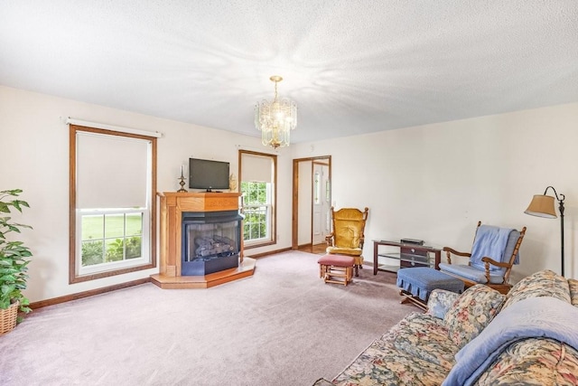 220 Winton Way Rd, Manchester, TN 37355 - carpeted living room featuring plenty of natural light, a chandelier, a fireplace with raised hearth, baseboards, and a textured ceiling