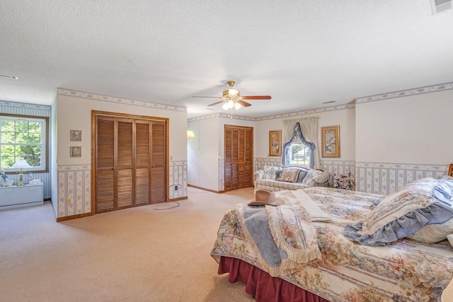 220 Winton Way Rd, Manchester, TN 37355 - bedroom with wainscoting, carpet floors, a textured ceiling, a ceiling fan, and multiple closets