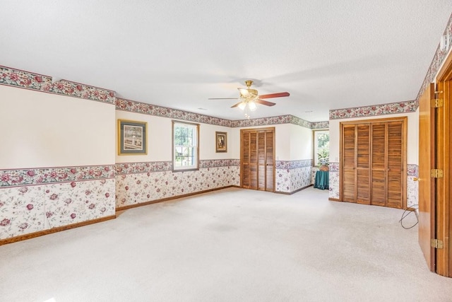 220 Winton Way Rd, Manchester, TN 37355 - unfurnished bedroom with wallpapered walls, carpet floors, wainscoting, and a ceiling fan