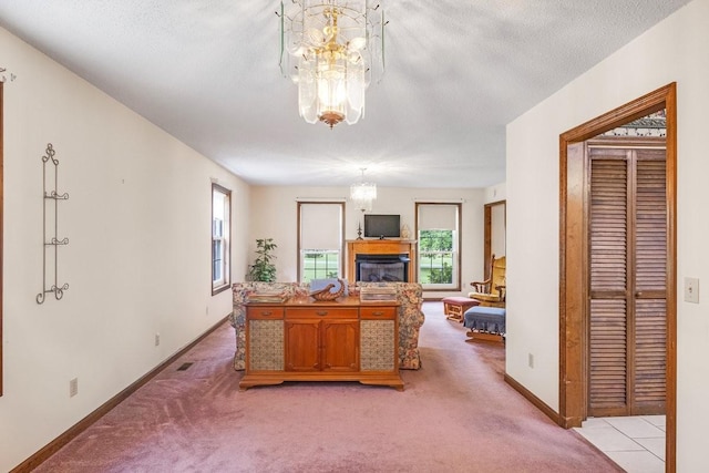 220 Winton Way Rd, Manchester, TN 37355 - living room featuring a chandelier, light colored carpet, a glass covered fireplace, and baseboards