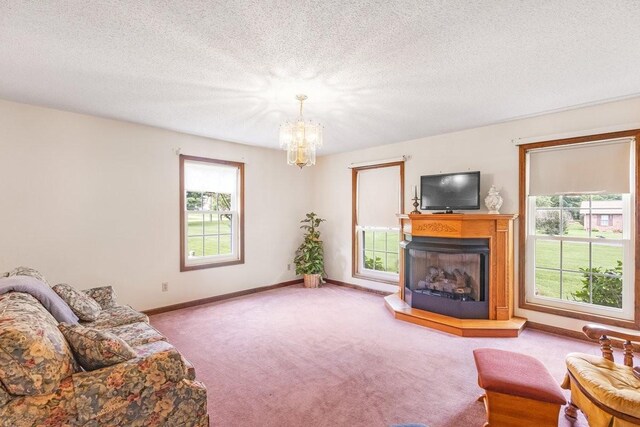 220 Winton Way Rd, Manchester, TN 37355 - living area featuring carpet, a chandelier, a fireplace with raised hearth, baseboards, and a textured ceiling