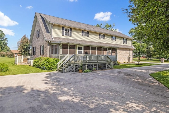 220 Winton Way Rd, Manchester, TN 37355 - view of front facade featuring a sunroom, a front yard, brick siding, central air condition unit, and roof with shingles