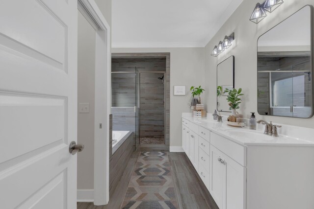 1240 Hensfield Dr, Murfreesboro, TN 37128 - bathroom featuring double vanity, a shower stall, a bath, baseboards, and wood finished floors