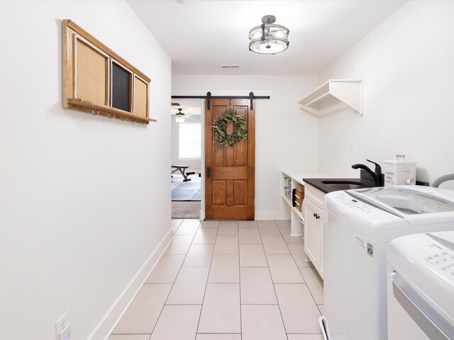 3005 Langston Pl, Spring Hill, TN 37174 - washroom featuring cabinet space, separate washer and dryer, a barn door, baseboards, and light tile patterned floors