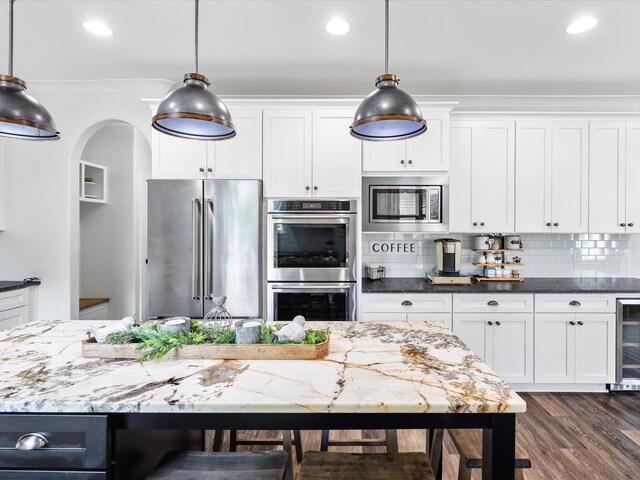 3005 Langston Pl, Spring Hill, TN 37174 - kitchen with stainless steel appliances, ornamental molding, white cabinets, beverage cooler, and dark wood-type flooring