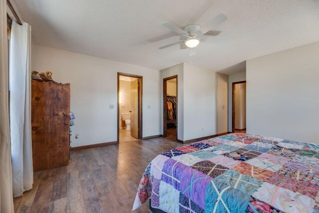 239 Henry Bayless Rd, Ardmore, TN 38449 - bedroom with wood finished floors, baseboards, a spacious closet, a textured ceiling, and ceiling fan