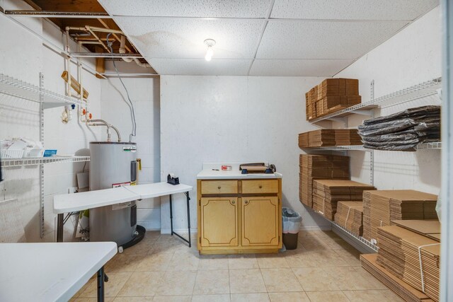 239 Henry Bayless Rd, Ardmore, TN 38449 - below grade area with electric water heater, a paneled ceiling, and light tile patterned flooring