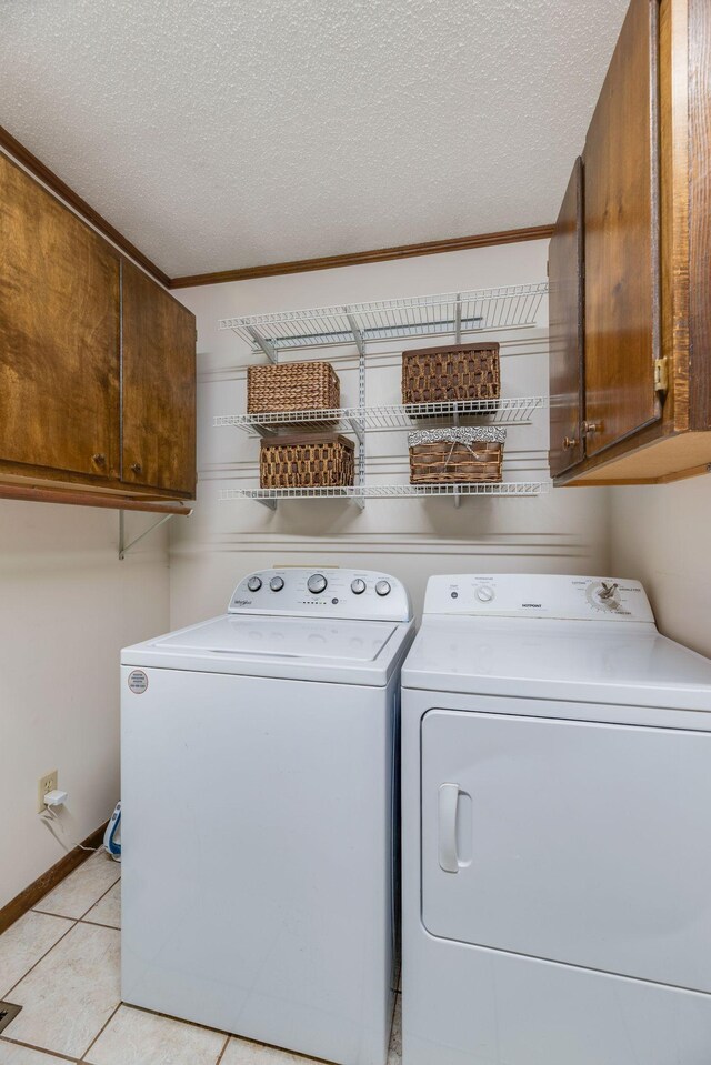 239 Henry Bayless Rd, Ardmore, TN 38449 - washroom featuring cabinet space, washing machine and dryer, a textured ceiling, and light tile patterned floors