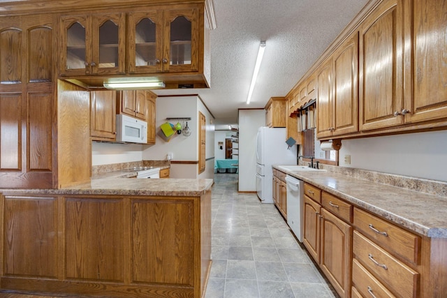 239 Henry Bayless Rd, Ardmore, TN 38449 - kitchen with white appliances, a textured ceiling, brown cabinets, a sink, and glass insert cabinets