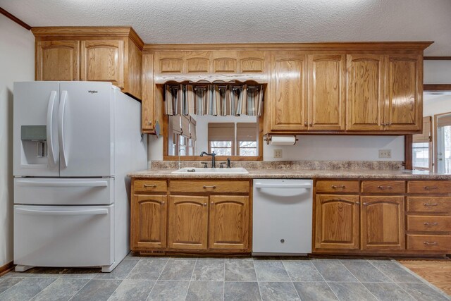 239 Henry Bayless Rd, Ardmore, TN 38449 - kitchen featuring white appliances, a sink, brown cabinetry, and a textured ceiling