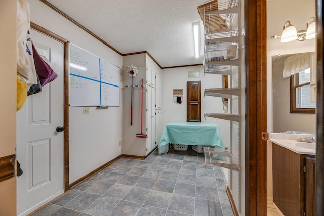 239 Henry Bayless Rd, Ardmore, TN 38449 - hallway with ornamental molding, a textured ceiling, baseboards, and a sink