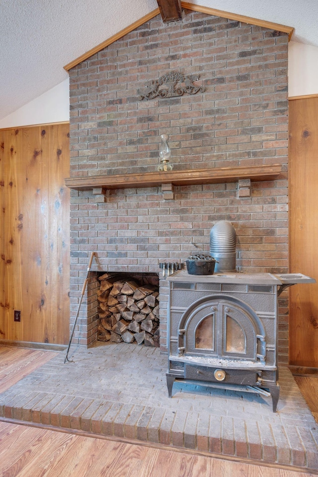 239 Henry Bayless Rd, Ardmore, TN 38449 - detailed view of a wood stove, wooden walls, wood finished floors, and a textured ceiling