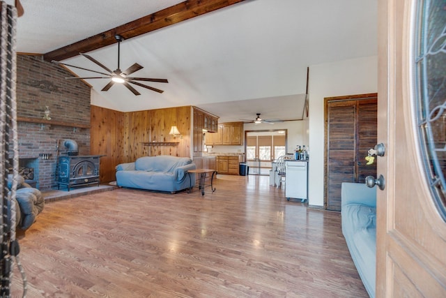 239 Henry Bayless Rd, Ardmore, TN 38449 - living room with ceiling fan, a wood stove, light wood-type flooring, and wood walls