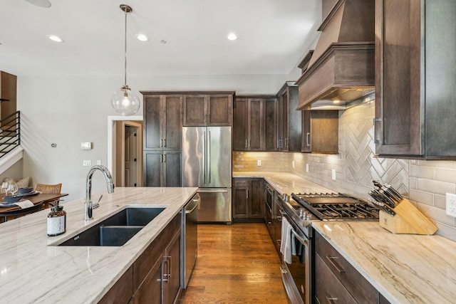 954 Russell St, Nashville, TN 37206 - kitchen with stainless steel appliances, a sink, custom exhaust hood, dark brown cabinetry, and light stone countertops