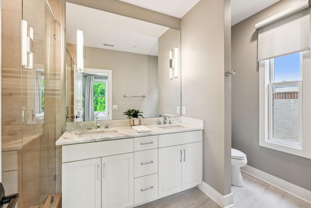 954 Russell St, Nashville, TN 37206 - bathroom with double vanity, a shower stall, toilet, baseboards, and tile patterned flooring