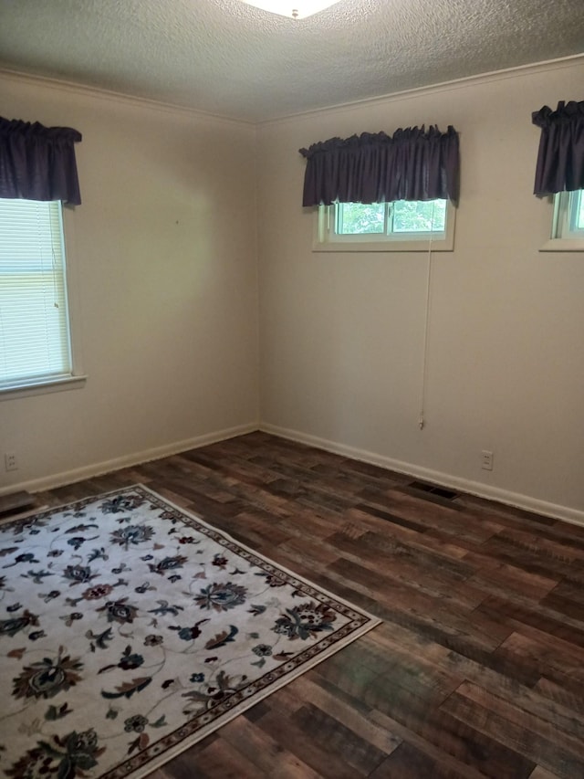 166 Westview St, Camden, TN 38320 - spare room with dark wood-style floors, healthy amount of natural light, a textured ceiling, and baseboards