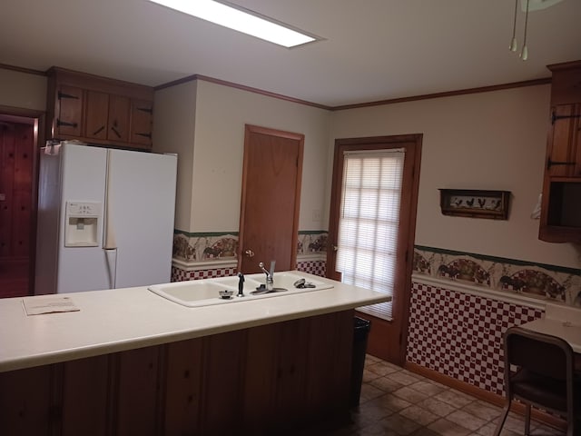 166 Westview St, Camden, TN 38320 - kitchen with white refrigerator with ice dispenser, a sink, wainscoting, light countertops, and crown molding