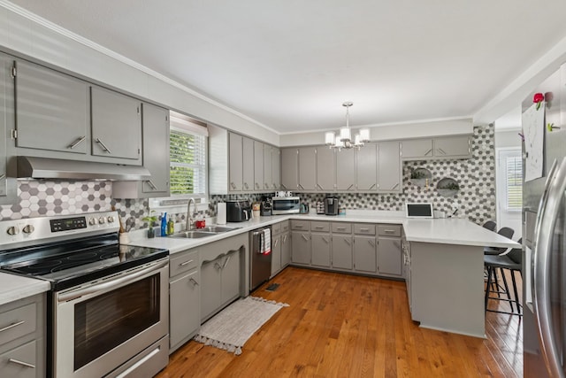 307 S Hummingbird Ln, Dickson, TN 37055 - kitchen featuring gray cabinets, appliances with stainless steel finishes, range hood, a sink, and a chandelier