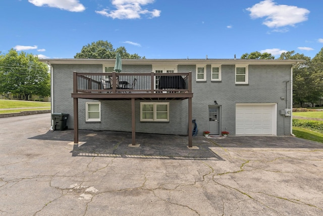 307 S Hummingbird Ln, Dickson, TN 37055 - back of property with brick siding, asphalt driveway, a wooden deck, and a garage