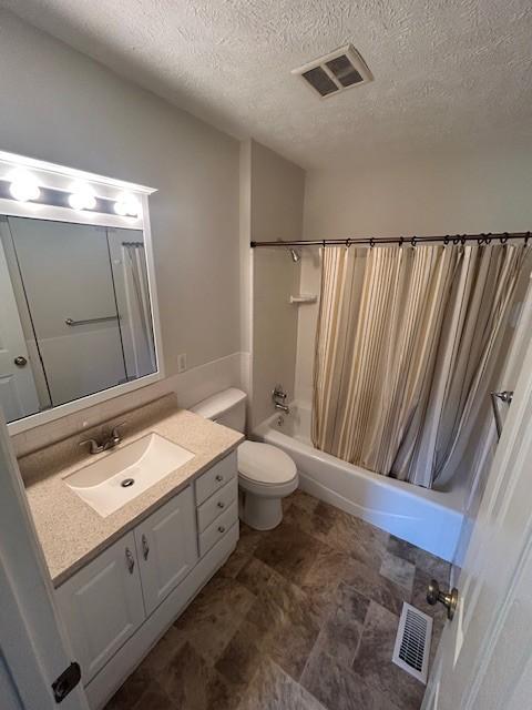 203 Arnold Ave, Tullahoma, TN 37388 - bathroom featuring shower / bath combo with shower curtain, vanity, toilet, and a textured ceiling