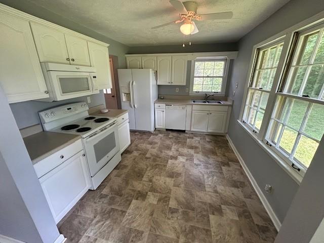 203 Arnold Ave, Tullahoma, TN 37388 - kitchen with white appliances, a sink, stone finish floors, baseboards, and a ceiling fan