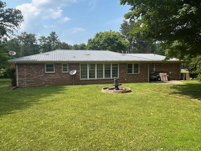 203 Arnold Ave, Tullahoma, TN 37388 - rear view of house featuring a yard, metal roof, and brick siding