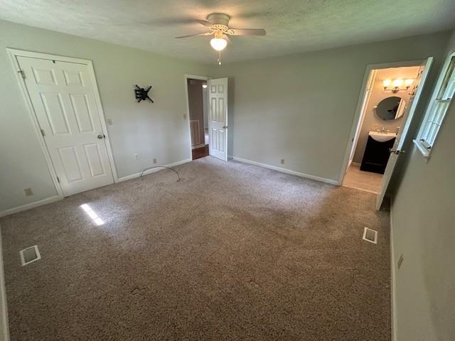 203 Arnold Ave, Tullahoma, TN 37388 - unfurnished bedroom with baseboards, light colored carpet, ceiling fan, and ensuite bath
