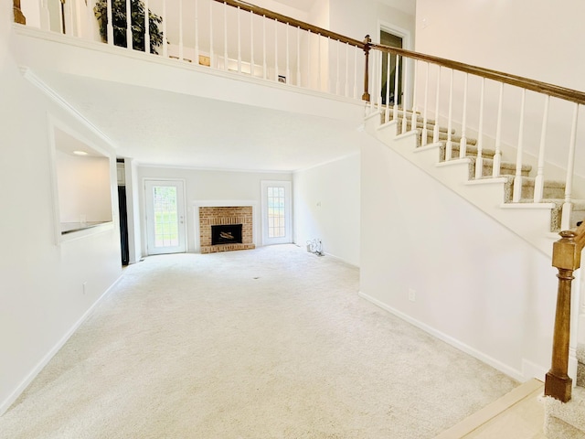 512 Riverview Dr, Franklin, TN 37064 - unfurnished living room featuring carpet flooring, a fireplace, stairs, baseboards, and crown molding