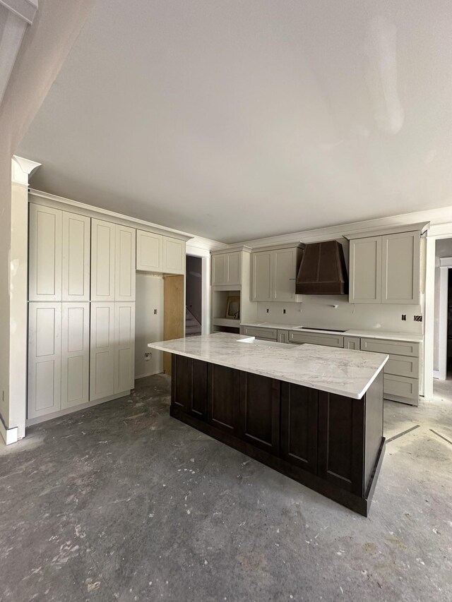 887 Ovoca Lake Rd, Tullahoma, TN 37388 - kitchen featuring custom exhaust hood, a large island, unfinished concrete floors, stovetop, and light stone counters