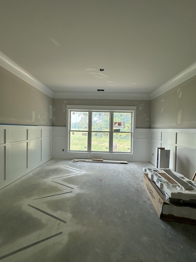 887 Ovoca Lake Rd, Tullahoma, TN 37388 - unfurnished living room featuring a decorative wall, plenty of natural light, crown molding, wainscoting, and concrete floors