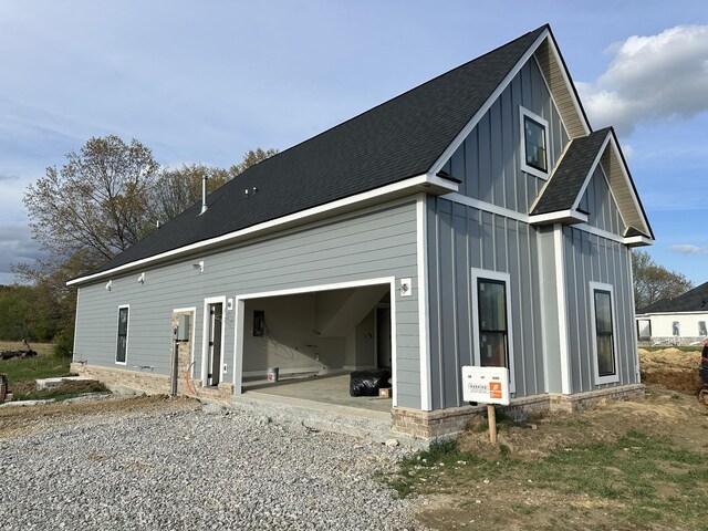 887 Ovoca Lake Rd, Tullahoma, TN 37388 - view of home's exterior with board and batten siding, gravel driveway, and roof with shingles