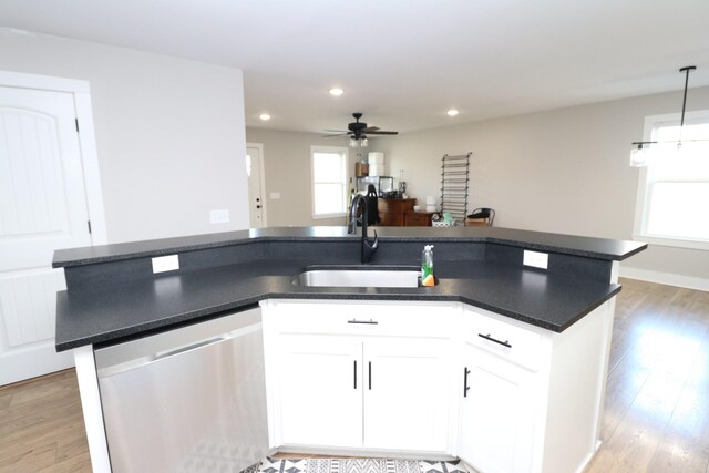 214 Miller Rd, Lafayette, TN 37083 - kitchen with stainless steel dishwasher, a sink, dark countertops, light wood-type flooring, and recessed lighting
