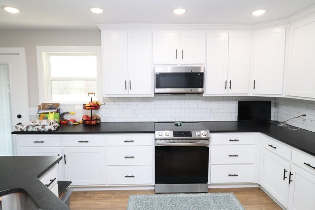 214 Miller Rd, Lafayette, TN 37083 - kitchen featuring appliances with stainless steel finishes, dark countertops, white cabinets, tasteful backsplash, and recessed lighting
