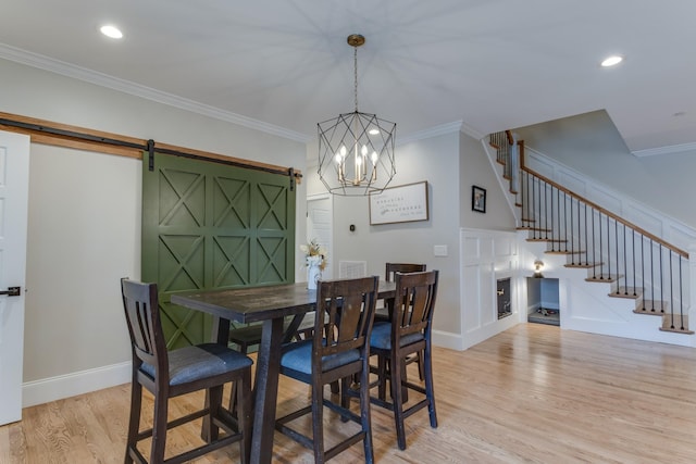 103 Maple St, Smyrna, TN 37167 - dining space with a barn door, light wood-style flooring, stairway, baseboards, and crown molding