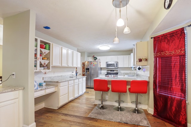 304 Baronswood Dr, Nolensville, TN 37135 - kitchen featuring stainless steel appliances, open shelves, light wood finished floors, and a sink